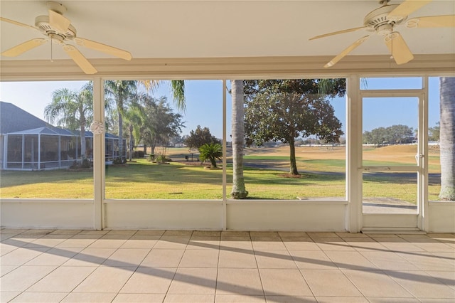 unfurnished sunroom with ceiling fan