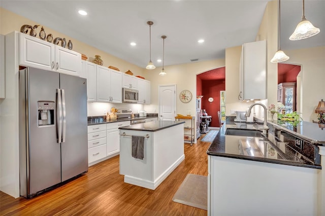 kitchen featuring a center island, white cabinetry, sink, decorative light fixtures, and stainless steel appliances