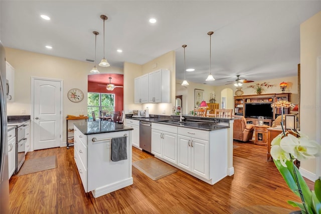 kitchen featuring sink, stainless steel dishwasher, pendant lighting, and white cabinetry