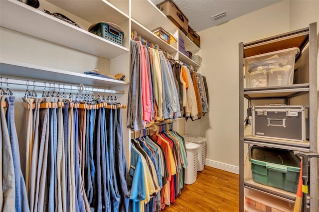 walk in closet with hardwood / wood-style floors