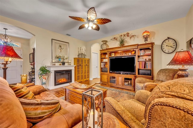 living room with ceiling fan with notable chandelier