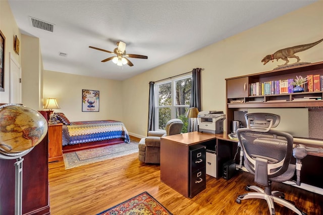 bedroom featuring wood-type flooring, a textured ceiling, and ceiling fan