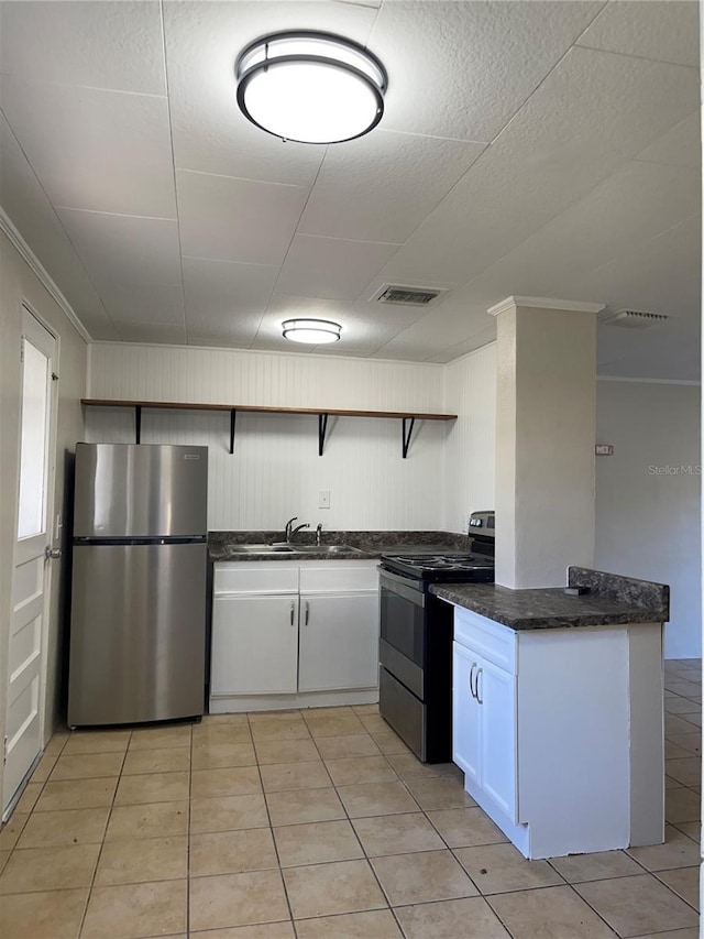 kitchen featuring light tile patterned flooring, appliances with stainless steel finishes, white cabinets, and sink