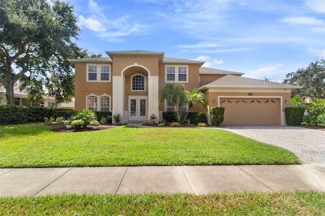 view of front of house with french doors, a garage, and a front yard