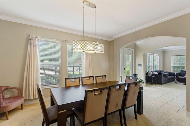 dining space featuring ornamental molding and light carpet