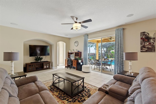 tiled living room with ceiling fan and a textured ceiling