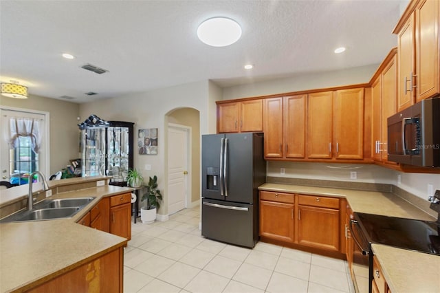 kitchen featuring stainless steel refrigerator with ice dispenser, light tile patterned floors, sink, and black / electric stove