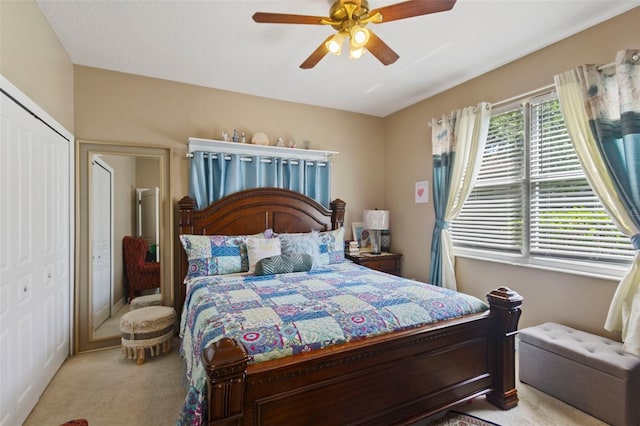 bedroom featuring ceiling fan, light colored carpet, and a closet