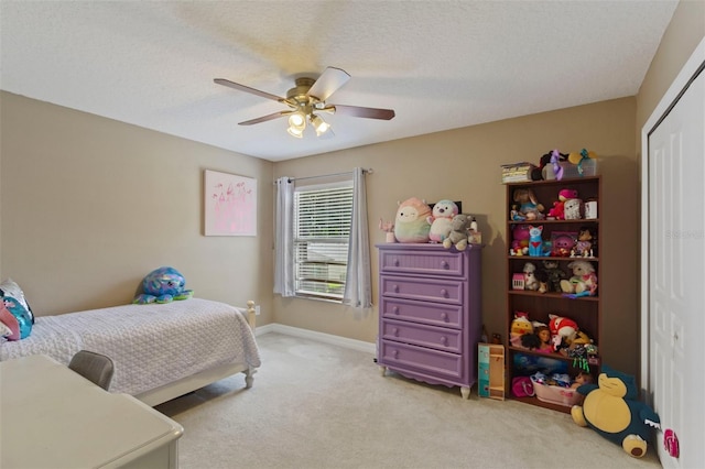 carpeted bedroom featuring ceiling fan, a textured ceiling, and a closet