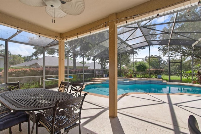 view of swimming pool with ceiling fan, glass enclosure, and a patio area