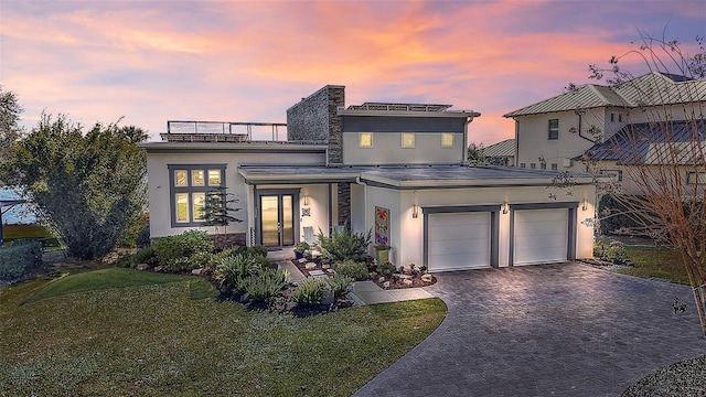 view of front of home with a lawn and a garage