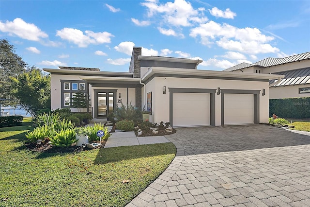 view of front of home with a garage, a front yard, and french doors