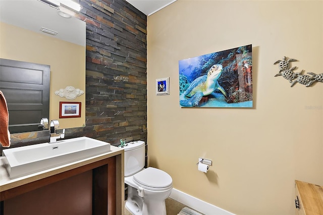 bathroom with toilet, vanity, and tile patterned flooring