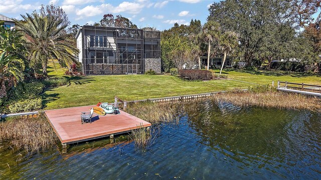 dock area with a lanai, a water view, and a lawn