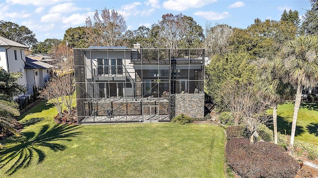 rear view of house featuring a balcony and a lawn