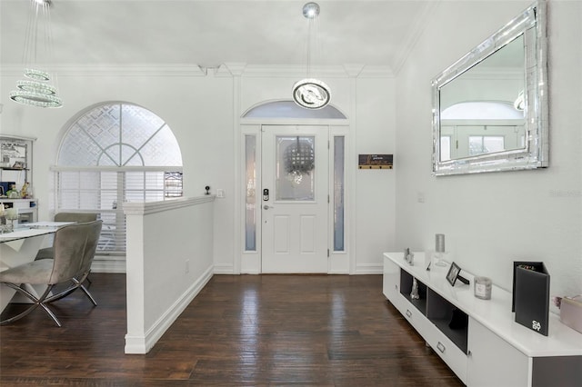 entryway with dark hardwood / wood-style floors, crown molding, and a chandelier