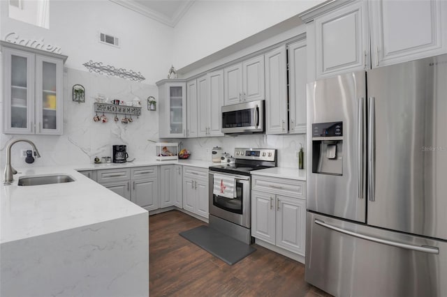 kitchen with tasteful backsplash, sink, light stone countertops, stainless steel appliances, and dark hardwood / wood-style flooring