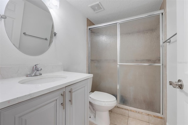 bathroom with toilet, tile patterned flooring, walk in shower, a textured ceiling, and vanity