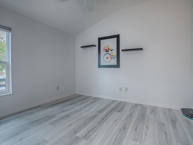 spare room with lofted ceiling and light hardwood / wood-style flooring