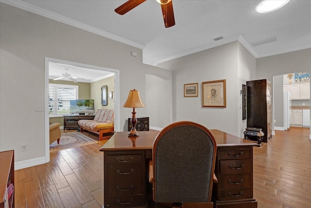 home office featuring light wood-type flooring, ornamental molding, and a textured ceiling