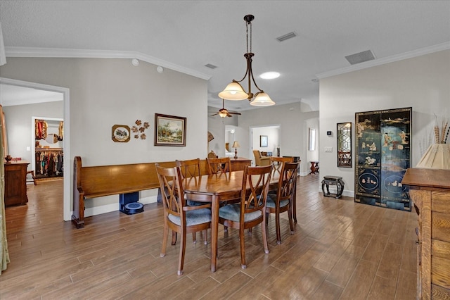 dining room with lofted ceiling, wood-type flooring, ornamental molding, and ceiling fan