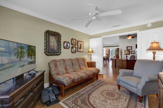 living room featuring a textured ceiling, ceiling fan, ornamental molding, and wood-type flooring