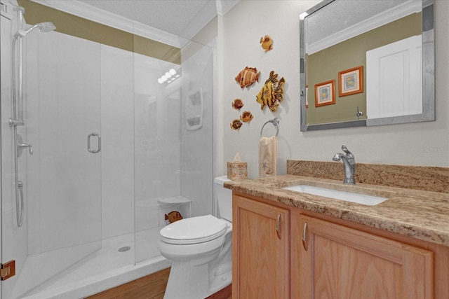 bathroom featuring toilet, vanity, a shower with shower door, ornamental molding, and a textured ceiling