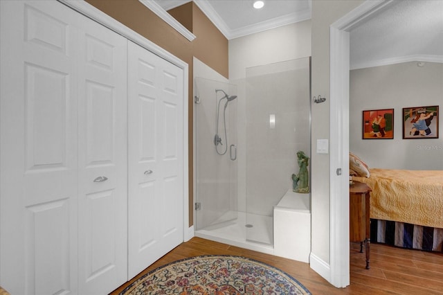 bathroom with hardwood / wood-style flooring, walk in shower, and crown molding