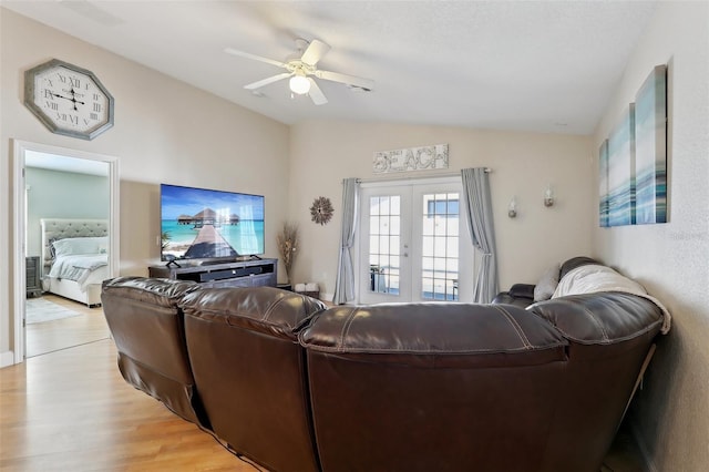 living room with vaulted ceiling, ceiling fan, light hardwood / wood-style floors, and french doors