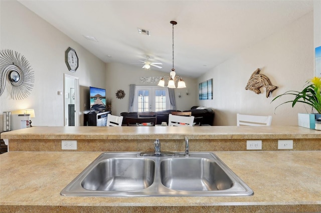 kitchen featuring sink, an inviting chandelier, hanging light fixtures, vaulted ceiling, and french doors