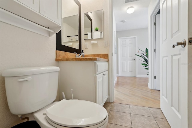 bathroom featuring vanity, tile patterned floors, and toilet