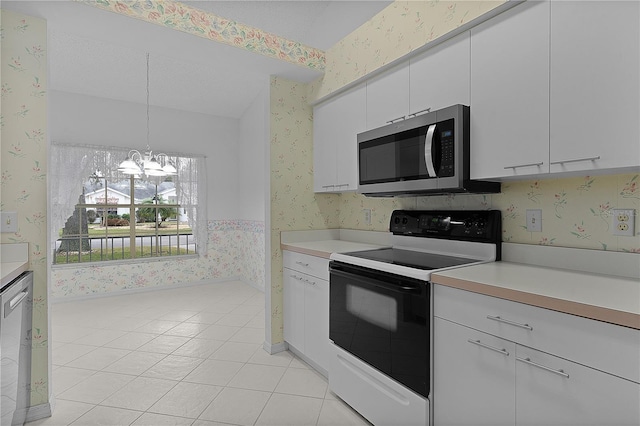 kitchen featuring light tile patterned floors, hanging light fixtures, stainless steel appliances, white cabinets, and a chandelier