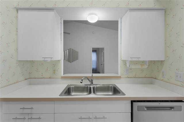 kitchen featuring dishwasher, sink, and white cabinets