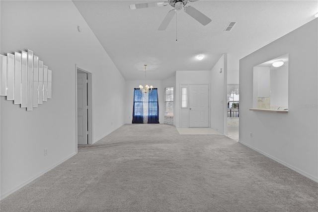 unfurnished living room with light colored carpet, lofted ceiling, ceiling fan with notable chandelier, and a textured ceiling