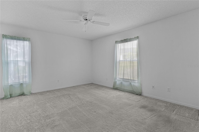 carpeted empty room with ceiling fan and a textured ceiling