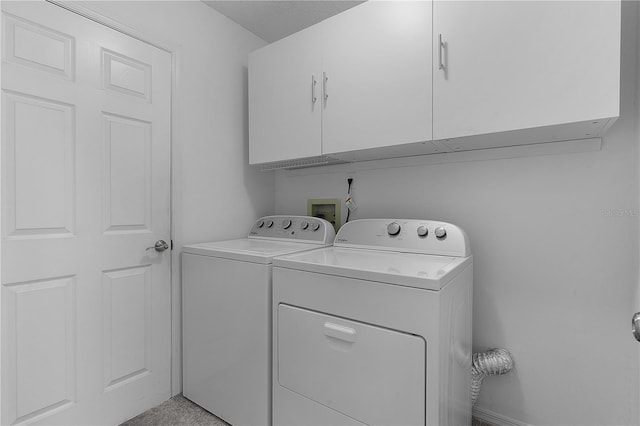 laundry area with cabinets, washing machine and dryer, and a textured ceiling