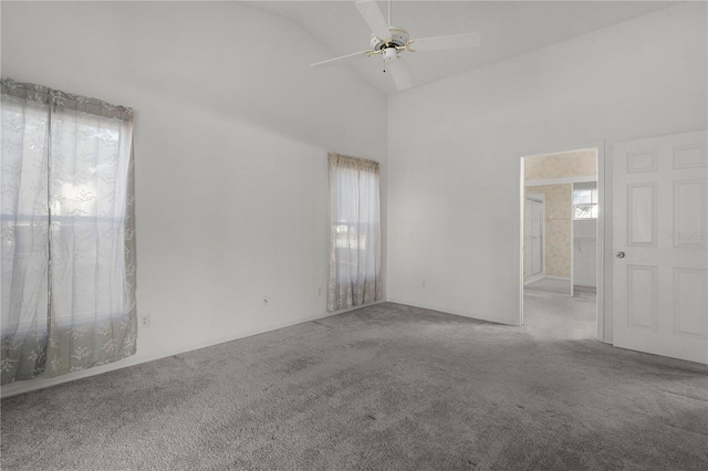 spare room with light carpet, plenty of natural light, and high vaulted ceiling