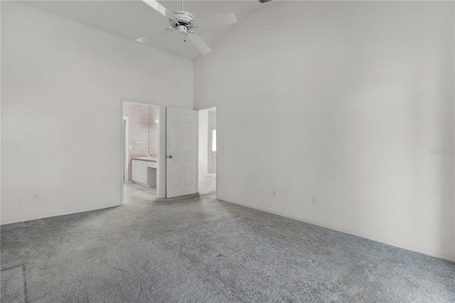 carpeted spare room featuring ceiling fan and high vaulted ceiling