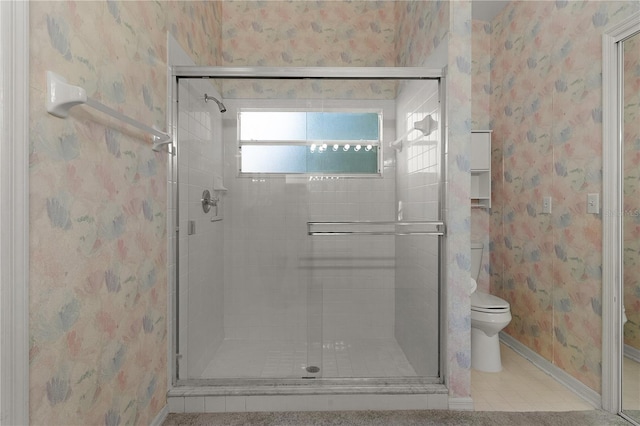 bathroom with a shower with door and toilet