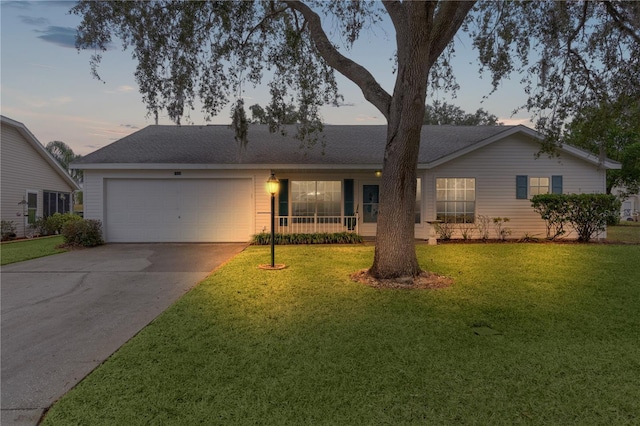 ranch-style house featuring a garage and a lawn