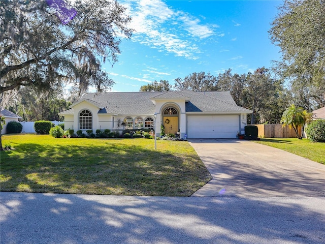 single story home with driveway, an attached garage, fence, a front lawn, and stucco siding