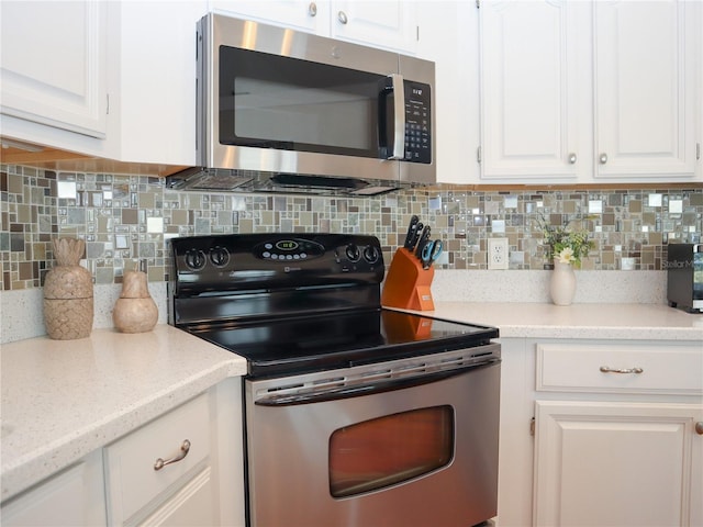 kitchen featuring stainless steel appliances, white cabinets, and tasteful backsplash