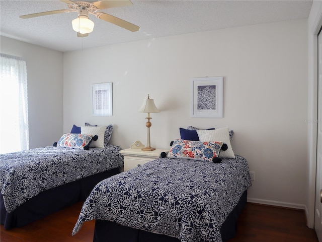 bedroom featuring baseboards, a ceiling fan, a textured ceiling, and wood finished floors