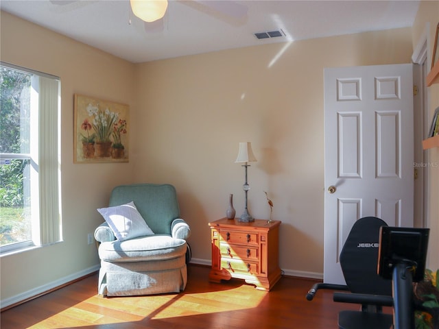 sitting room featuring a ceiling fan, wood finished floors, visible vents, and baseboards