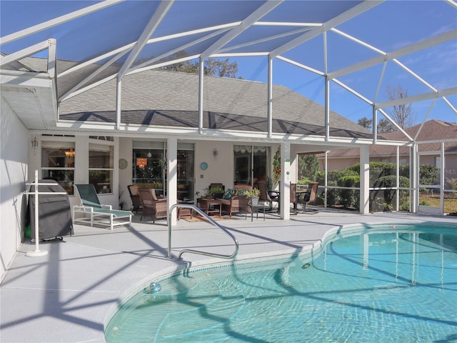 outdoor pool with a patio, outdoor lounge area, and glass enclosure