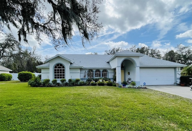 ranch-style house with driveway, a garage, a front lawn, and stucco siding