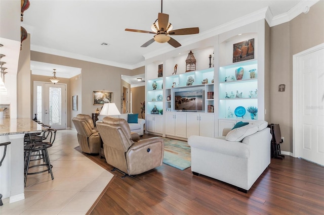 living room with hardwood / wood-style flooring, ornamental molding, ceiling fan, and built in shelves