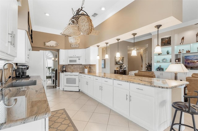 kitchen with light stone countertops, sink, white cabinets, and white appliances