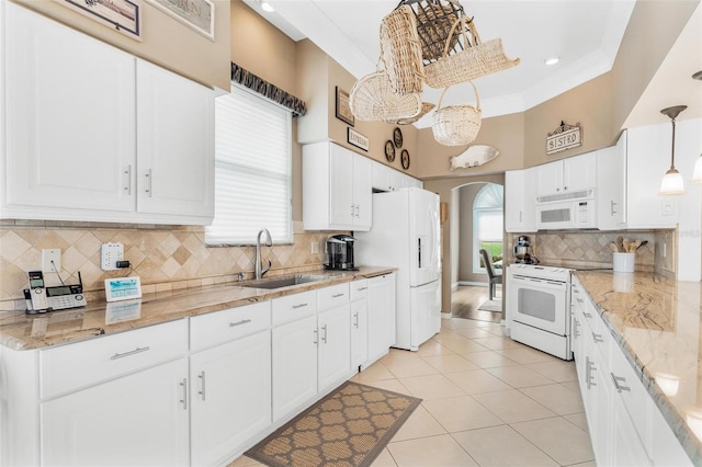 kitchen featuring hanging light fixtures, white appliances, sink, and backsplash