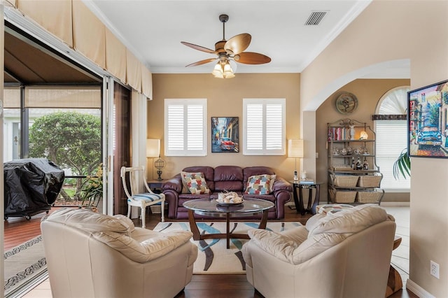 living room featuring crown molding, a healthy amount of sunlight, and ceiling fan